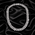 Iced out Cuban link chain necklace on black satin with crystal sparkle lighting